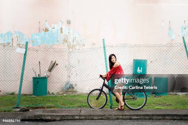 singaporean woman on a bike in an alley - singapore alley stock pictures, royalty-free photos & images