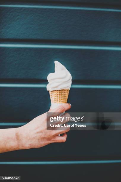 closeup image hand holding a vanilla ice cream - vanille roomijs stockfoto's en -beelden