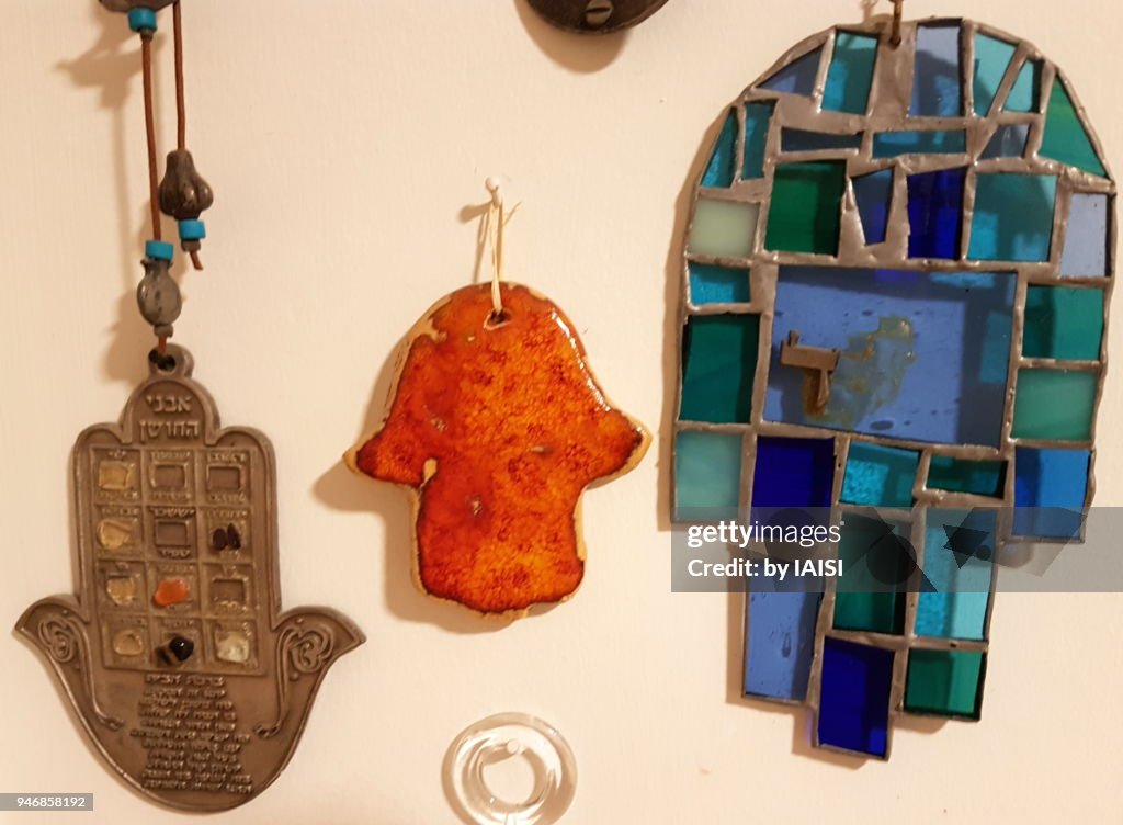 Three hamsa symbols, in metal, terracotta, blue vitrail glass