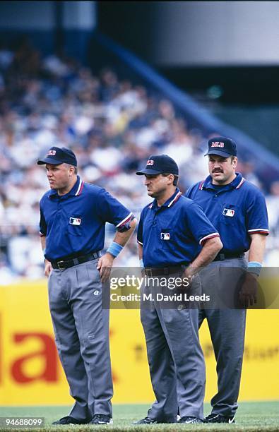 Umpires Brian O'Nora, Mark Hirschbeck and Wally Bell look on during the New York Yankees game against the Chicago White Sox at Yankee Stadium on June...