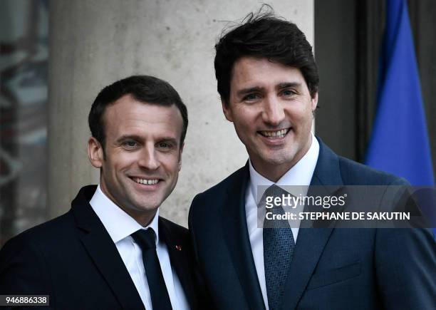 French President Emmanuel Macron welcomes Canadian Prime Minister Justin Trudeau upon his arrival at the Elysee Palace in Paris, on April 16, 2018.