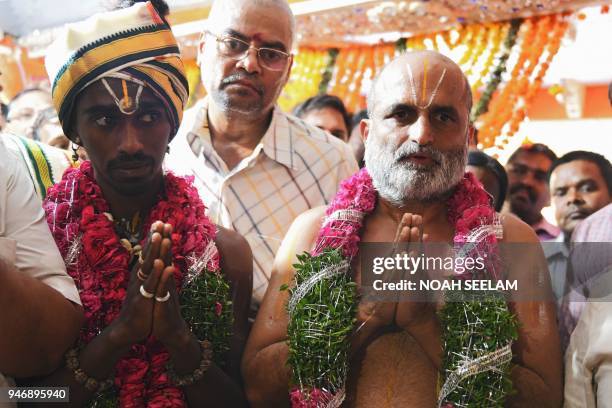 An Indian Hindu priest CS Rangarajan performs rituals along with a Dalit devotee Aditya Parasri after carrying him on his shoulders into the sanctum...