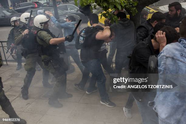 Greek Communist Party supporters clash with police forces as they try to bring down a statue of former US President Harry Truman during a...