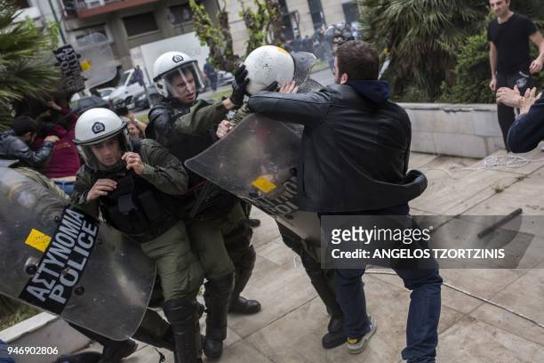 Greek Communist Party supporters clash with police forces as they try to bring down a statue of former US President Harry Truman during a...