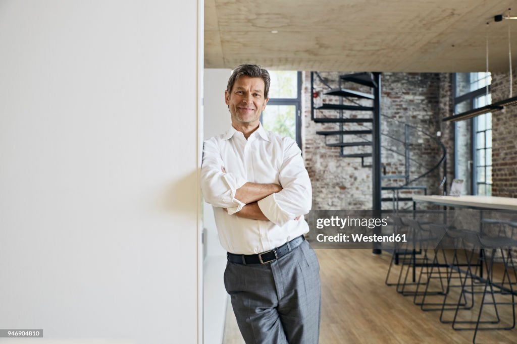 Portrait of smiling businessman in modern office