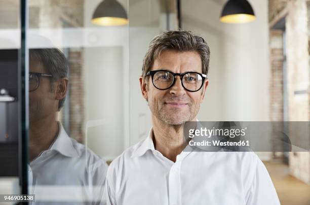 portrait of smiling businessman wearing glasses - kopfbild stock-fotos und bilder