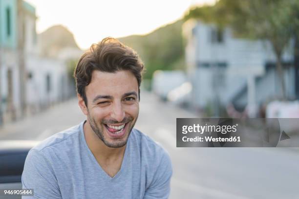 portrait of laughing young man pulling funny faces - entrecerrar los ojos fotografías e imágenes de stock