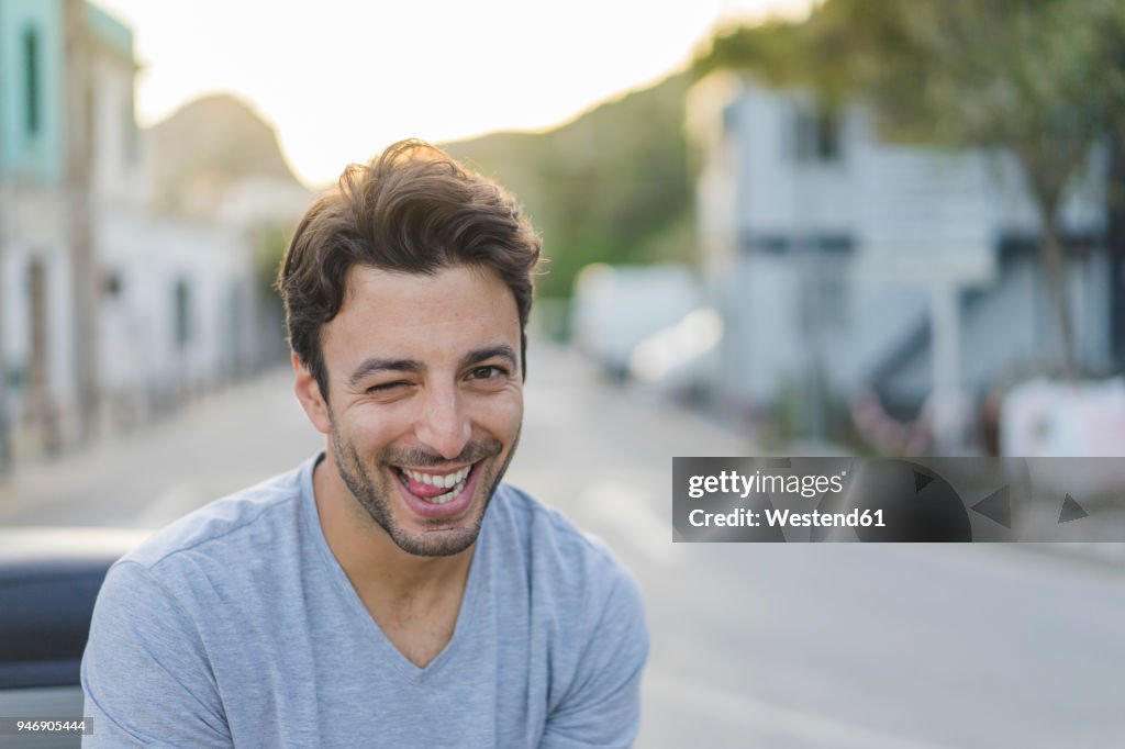 Portrait of laughing young man pulling funny faces