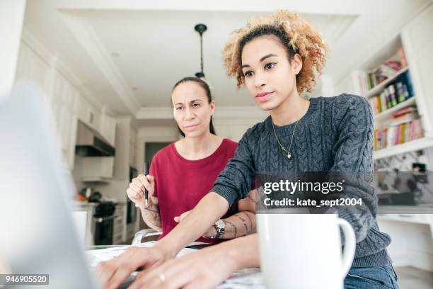 lgbtq couple testing a new laptop - lesbian couple stock pictures, royalty-free photos & images