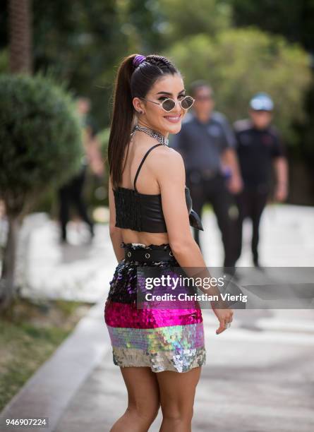 Camila Coelho wearing bikini top, striped skirt, ankle boots is seen at Revolve Festival on April 15, 2018 in Indio, California.