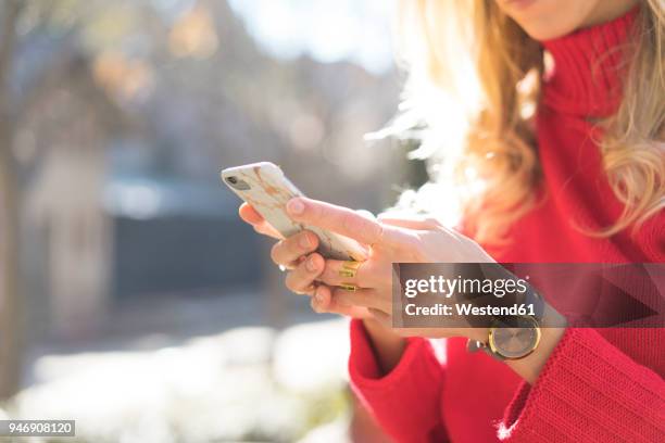 close-up of woman using smartphone in a garden - sending sms stock pictures, royalty-free photos & images