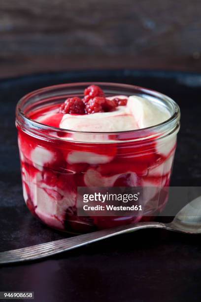 glass of vanilla custard with raspberries on dark ground - raspberry coulis stock pictures, royalty-free photos & images