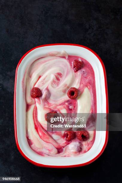 bowl of vanilla custard with raspberries on dark ground - raspberry coulis stock pictures, royalty-free photos & images