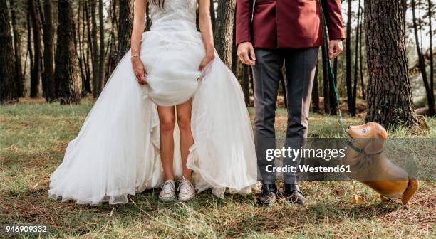 low section of bride and groom in forest with funny dog-shaped balloon - married imagens e fotografias de stock