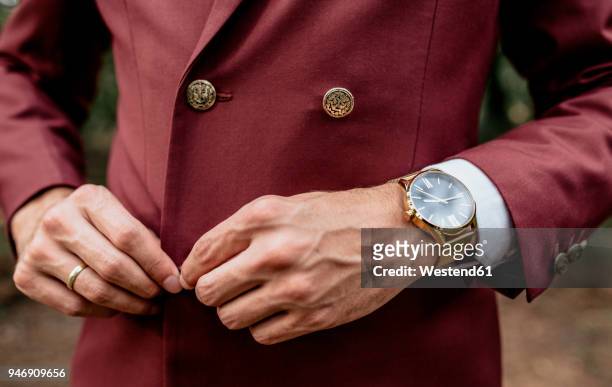 close-up of man wearing a suit and golden watch buttoning his jacket - men watches stock pictures, royalty-free photos & images