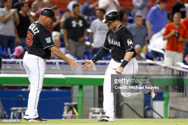 Justin Bour of the Miami Marlins high fives third base coach Fredi Gonzalez after hitting a two-run home run against the Pittsburgh Pirates at...