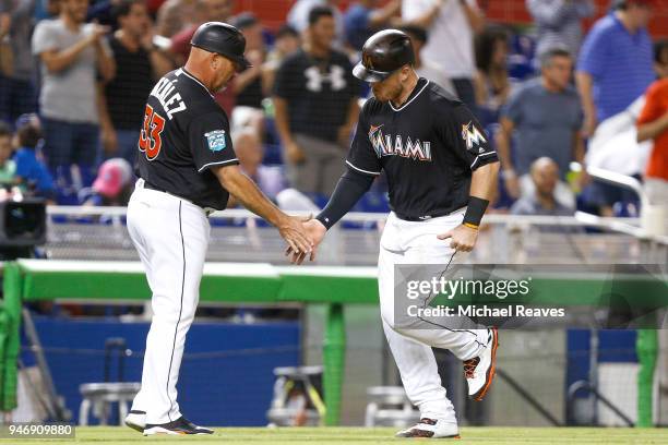 Justin Bour of the Miami Marlins high fives third base coach Fredi Gonzalez after hitting a two-run home run against the Pittsburgh Pirates at...