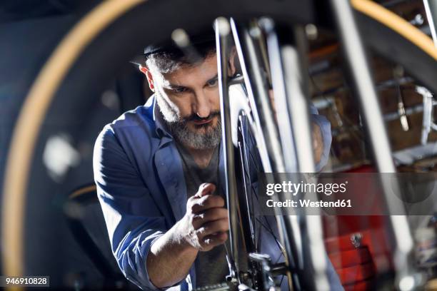 man working on bicycle in workshop - business passion stock pictures, royalty-free photos & images