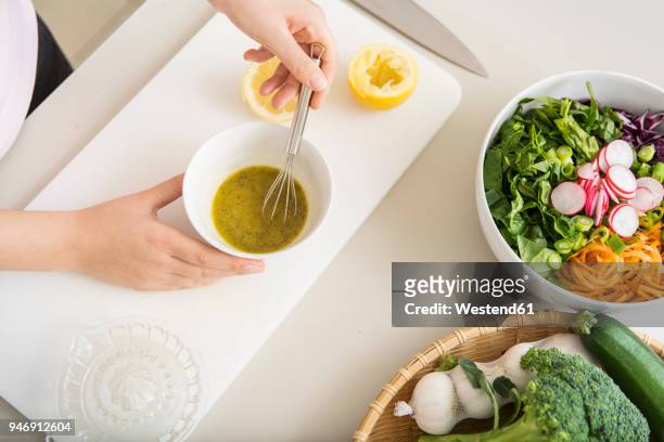 young woman preparing a fresh salad dressing - vinaigrette dressing photos et images de collection