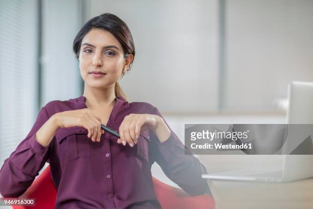 portrait of confident businesswoman with laptop in office - purple shirt - fotografias e filmes do acervo