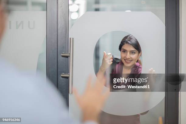businesswoman knocking on glass door - knocking photos et images de collection