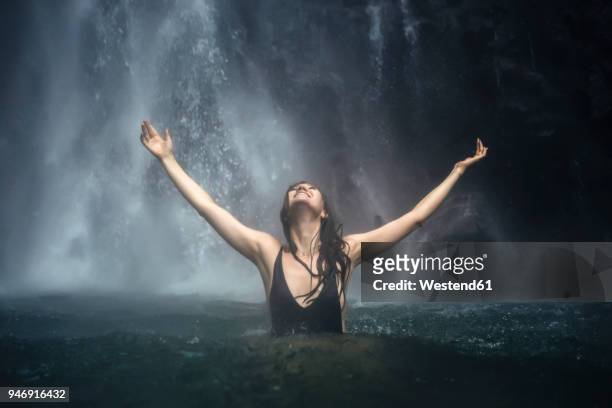 indonesia, bali, young woman bathing at sekumpul waterfall - wasserfall stock-fotos und bilder
