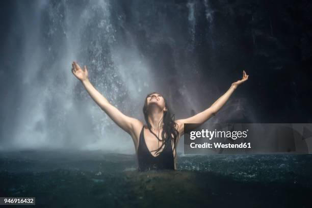 indonesia, bali, young woman bathing at sekumpul waterfall - exhilaration stock pictures, royalty-free photos & images