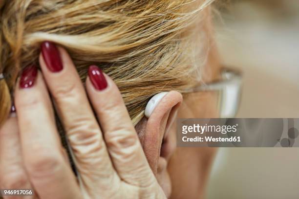 close-up of senior woman with hearing aid - ear close up women stock-fotos und bilder