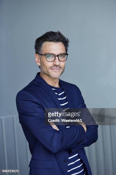 portrait of stylish businessman with stubble wearing blue suit and glasses - man jacket stock pictures, royalty-free photos & images