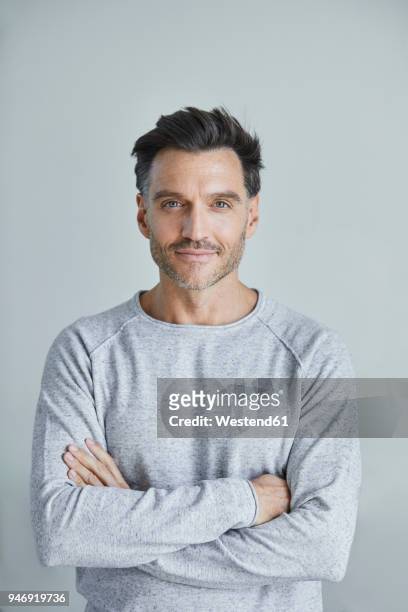 portrait of smiling man with stubble wearing grey sweatshirt - männer über 40 stock-fotos und bilder