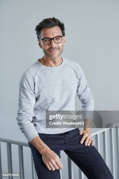 portrait of smiling man with stubble wearing grey sweatshirt and glasses - encuadre de tres cuartos fotografías e imágenes de stock