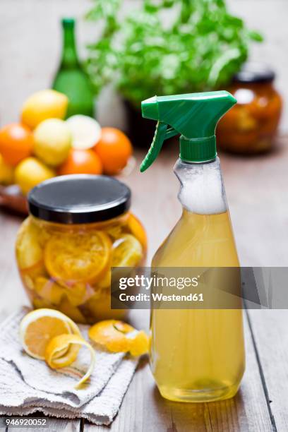 homemade cleansing agent, vinegar, peels of citrus fruits, ginger and water - azijn stockfoto's en -beelden