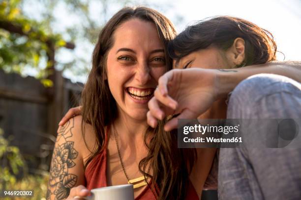 two happy young women hugging outdoors - drinking in yard stock pictures, royalty-free photos & images