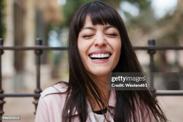 portrait of laughing young woman outdoors - rire aux éclats photos et images de collection