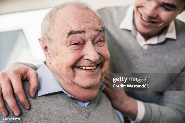 portrait of happy senior man with young man - grandfather face stock-fotos und bilder