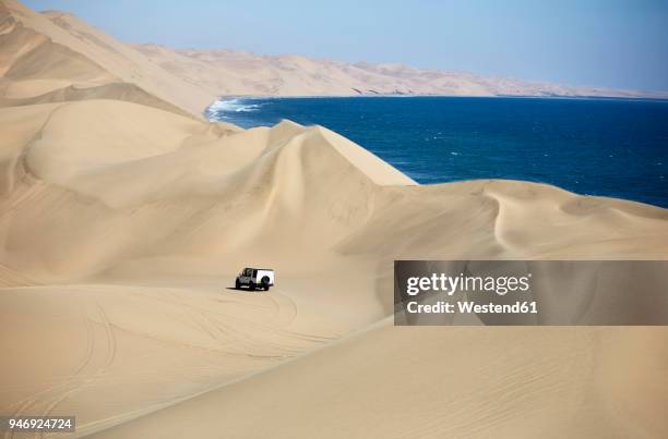 africa, namibia, namib-naukluft national park, namib desert, atlantic and desert dunes, off-road vehicle - namib desert stock-fotos und bilder