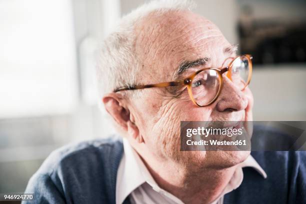 portrait of smiling senior man looking sideways - senior man stock-fotos und bilder