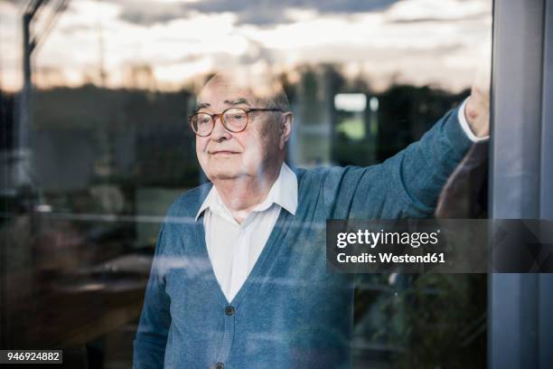 portrait of serious man at the window looking out - window reflection stock pictures, royalty-free photos & images