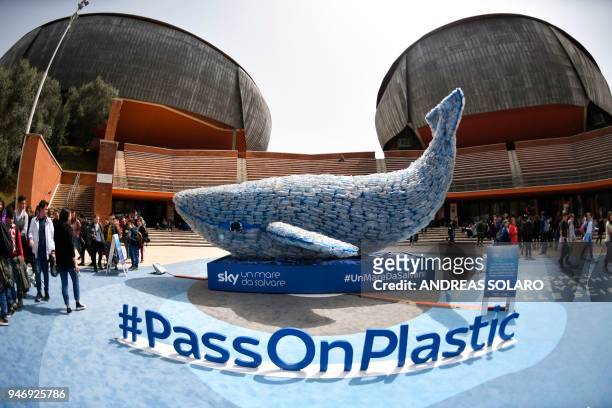 People look at "Plasticus", a 10-metre installation depicting a whale created by "Sky Ocean Rescue-A Sea to Save", and made up of 250 kg of plastic...