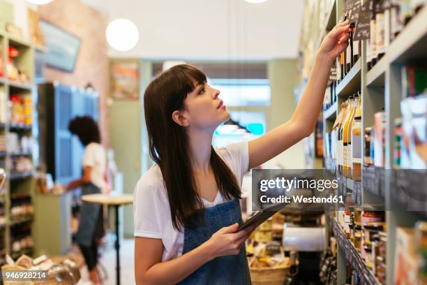 woman with tablet at shelf in a store - business checklist stock pictures, royalty-free photos & images