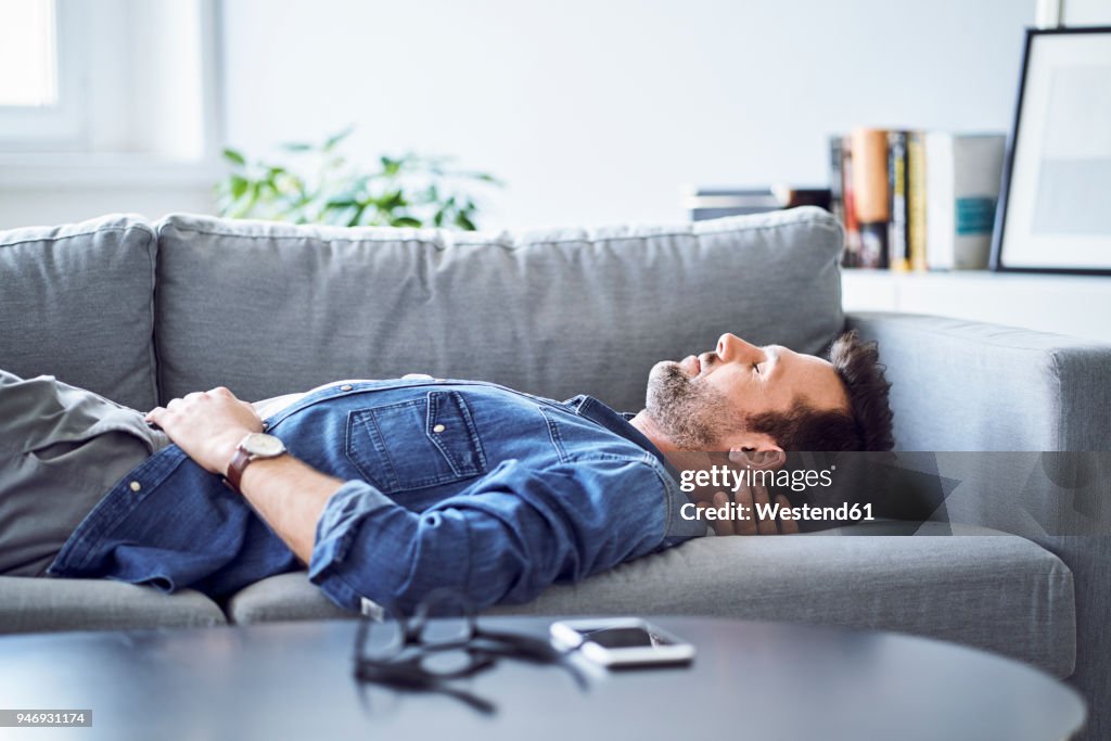 Relaxed man sleeping on sofa