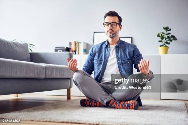 relaxed man meditating at home - 胡坐　横 ストックフォトと画像