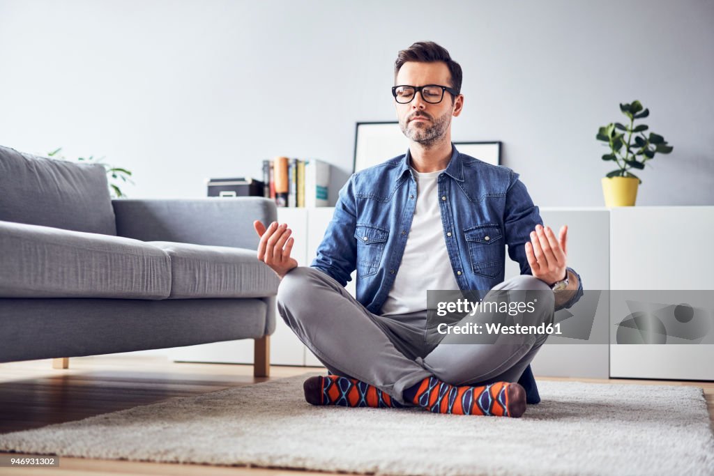 Relaxed man meditating at home