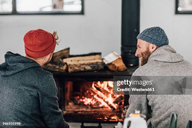 two men sitting at fireplace - hygge bildbanksfoton och bilder
