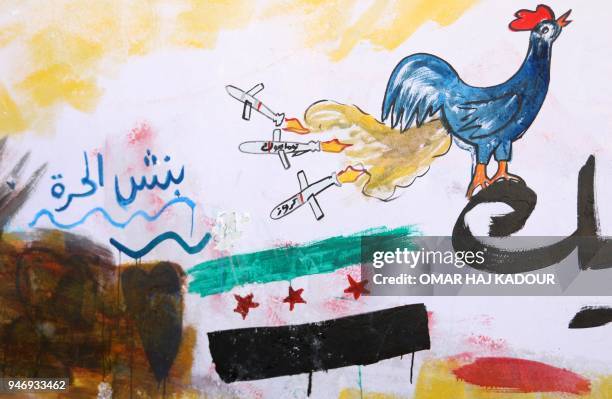 Picture taken on April 16, 2018 in the rebel-held Syrian town of Binnish shows a graffiti drawn by 45-year-old Syrian artist Aziz al-Asmar depicting...