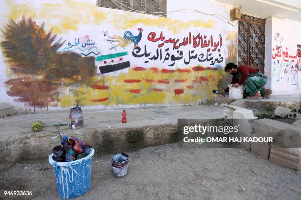 Picture taken on April 16, 2018 in the rebel-held Syrian town of Binnish shows a graffiti drawn by 45-year-old Syrian artist Aziz al-Asmar, with a...