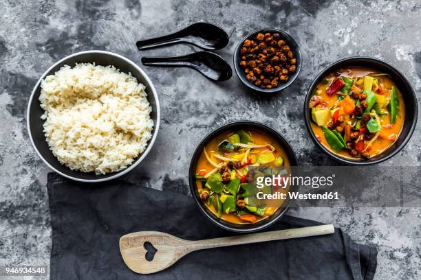 red curry in bowls, rice and roasted chickpeas - achards photos et images de collection
