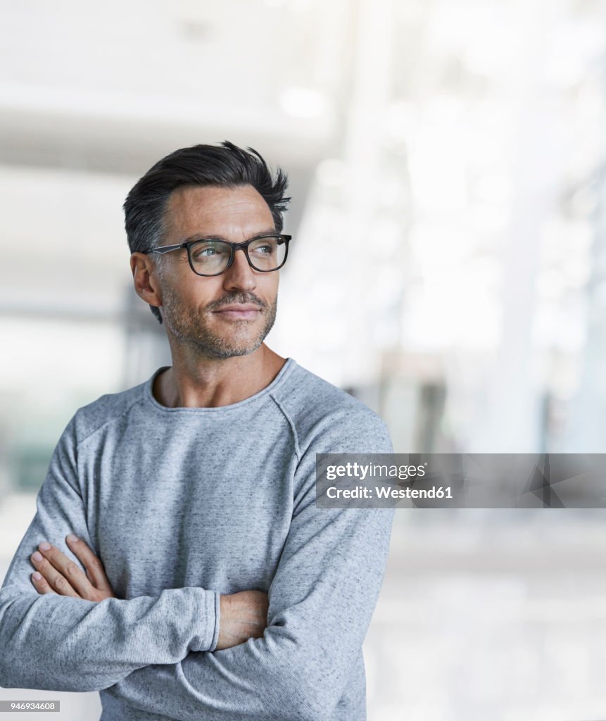 Portrait of content mature man with stubble wearing glasses