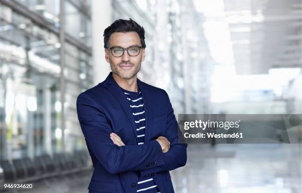 portrait of stylish businessman with stubble wearing blue suit and glasses - guy stubble stock pictures, royalty-free photos & images