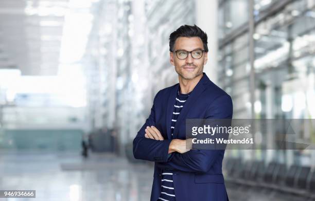 portrait of stylish businessman with stubble wearing blue suit and glasses - businessman in suit ストックフォトと画像